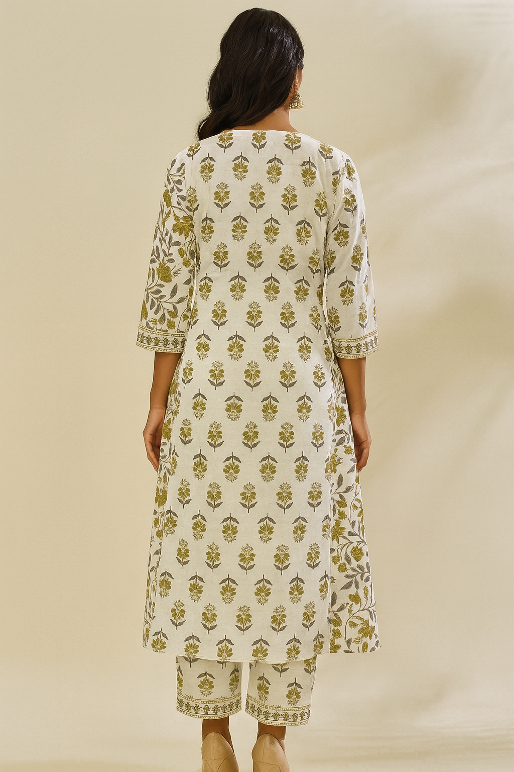 Woman wearing a white kurta with green floral pattern on a beige background