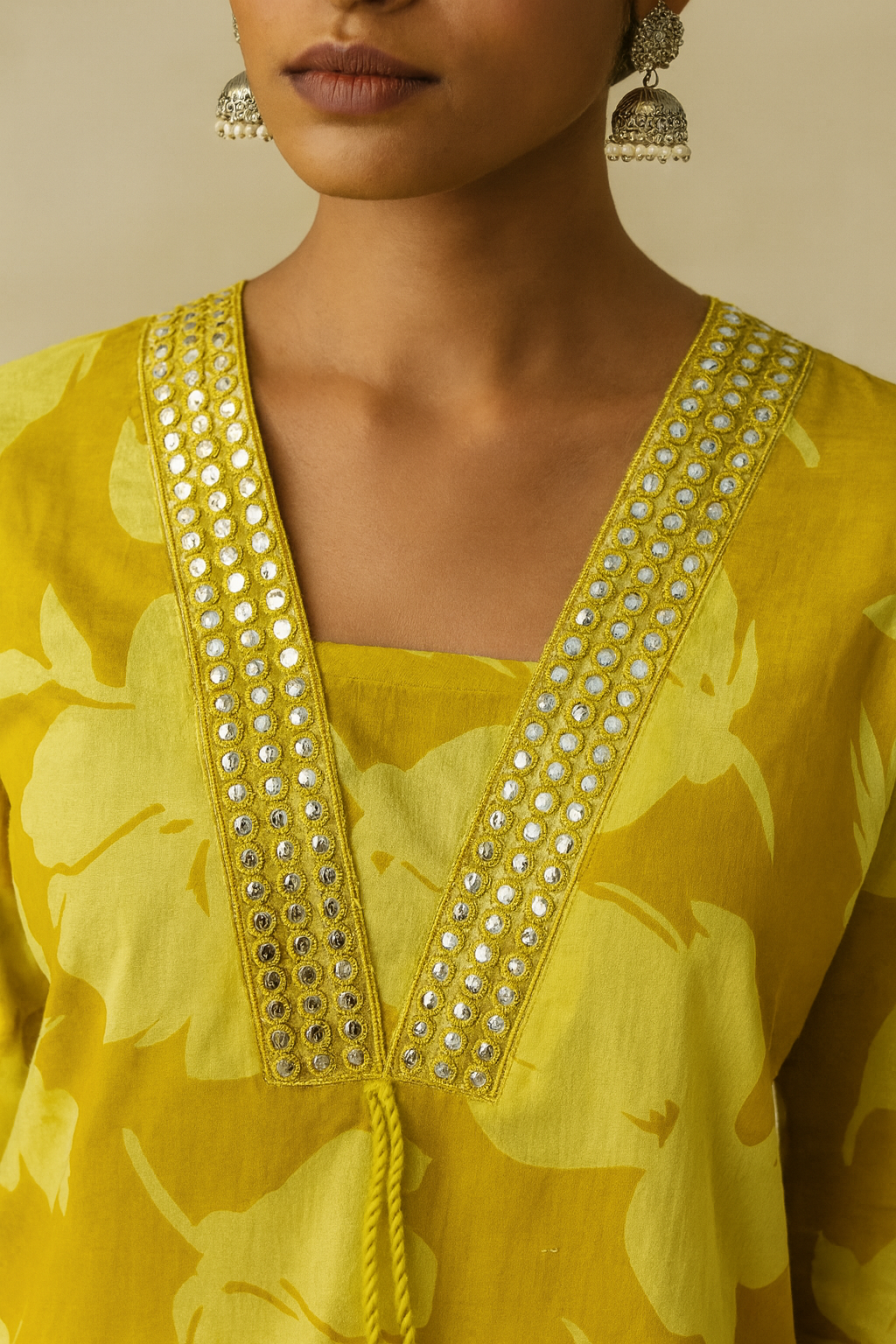 Yellow floral dress with intricate detailing on a neutral background