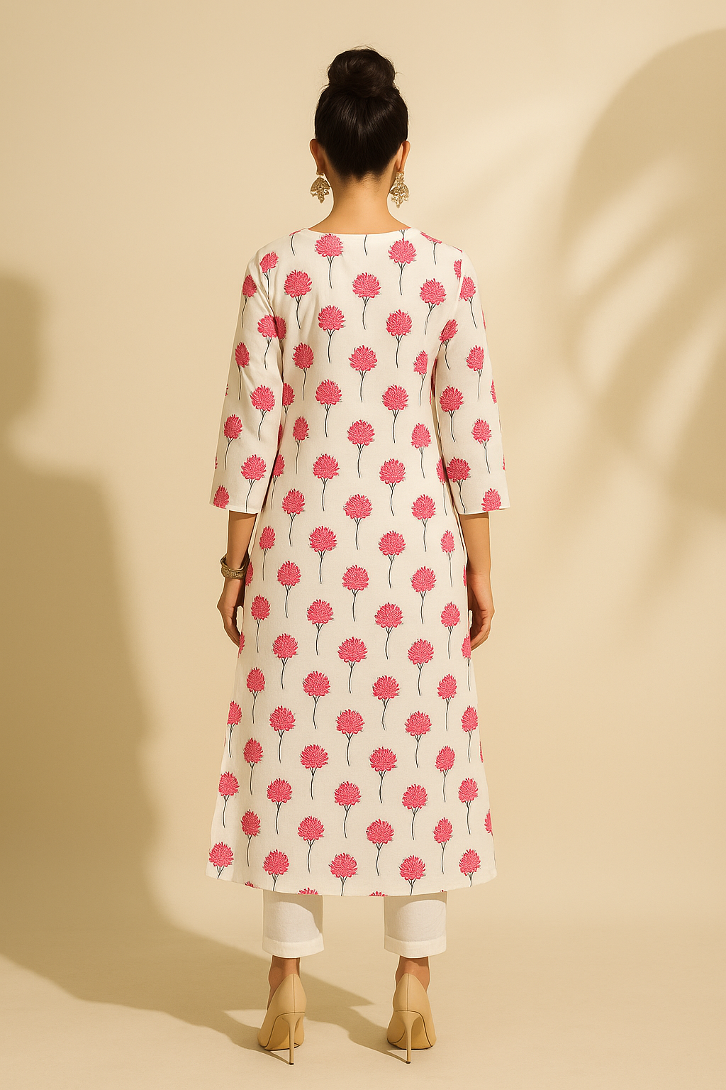 Woman wearing a white kurta with pink floral pattern on a beige background