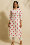 Woman wearing a floral printed kurta against a beige background