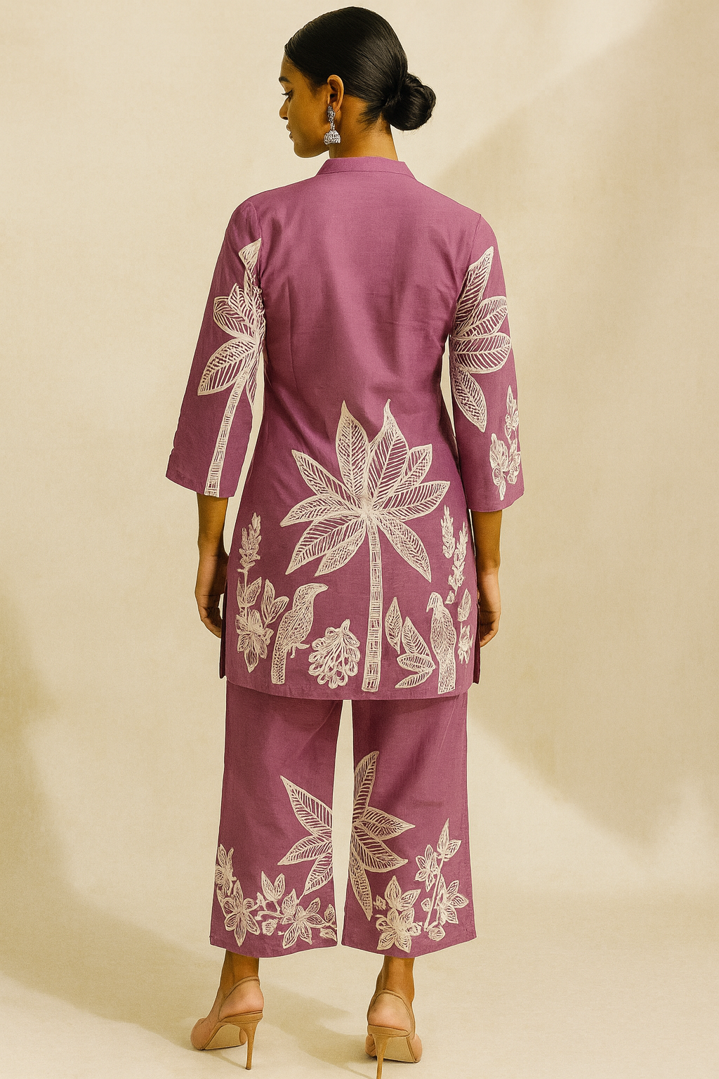 Woman wearing a mauve outfit with white floral embroidery on a beige background